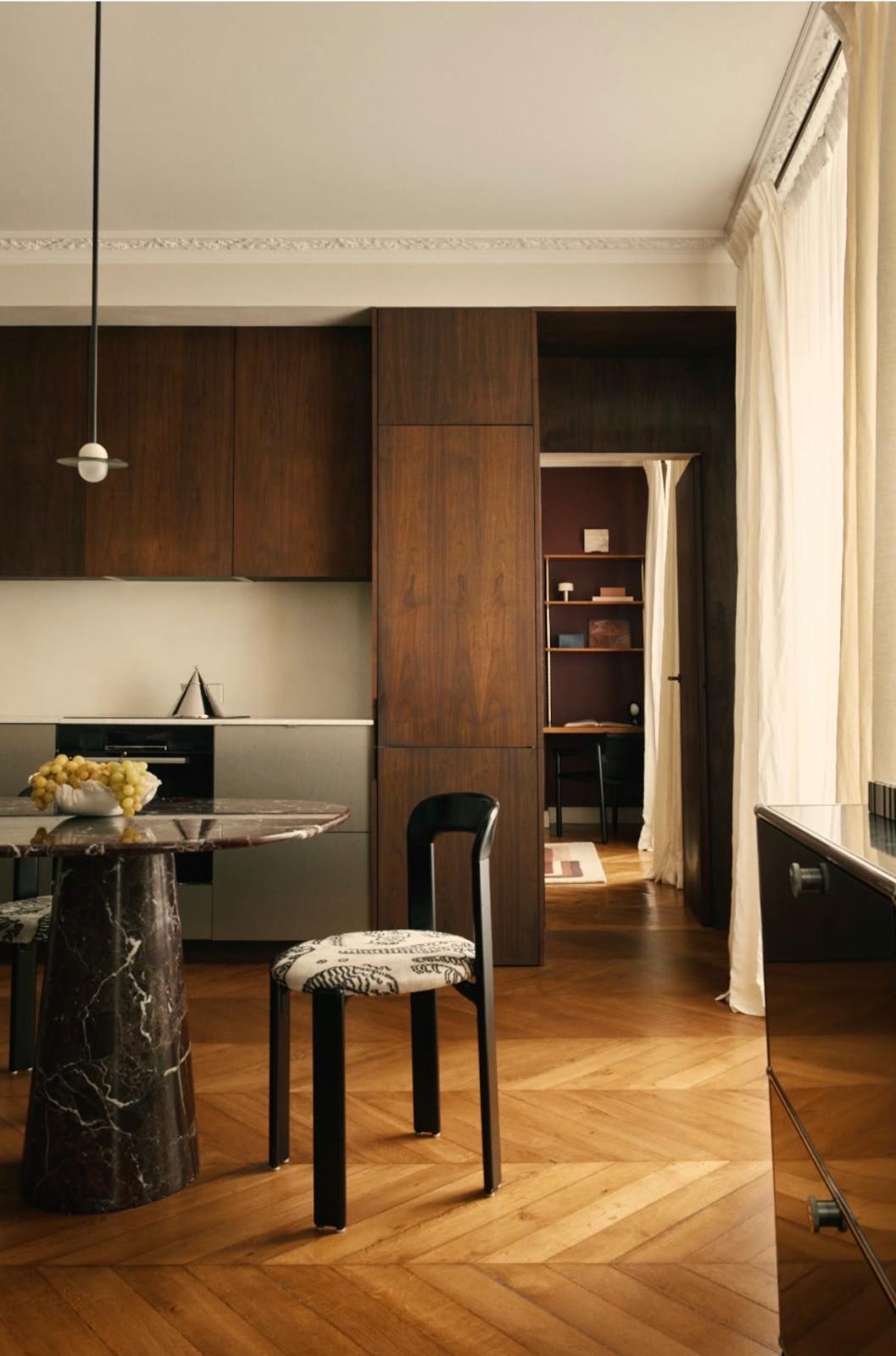 Cuisine et salle à manger avec table en marbre rouge et parquet à chevrons