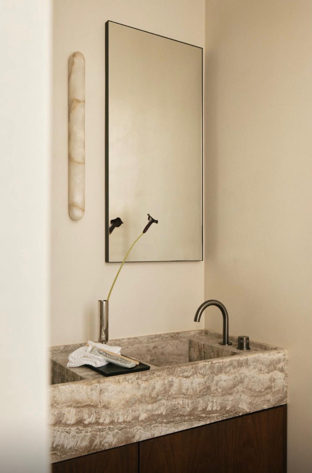 Salle d'eau : vasque taillée dans la pierre, applique en albâtre et meuble en noyer
