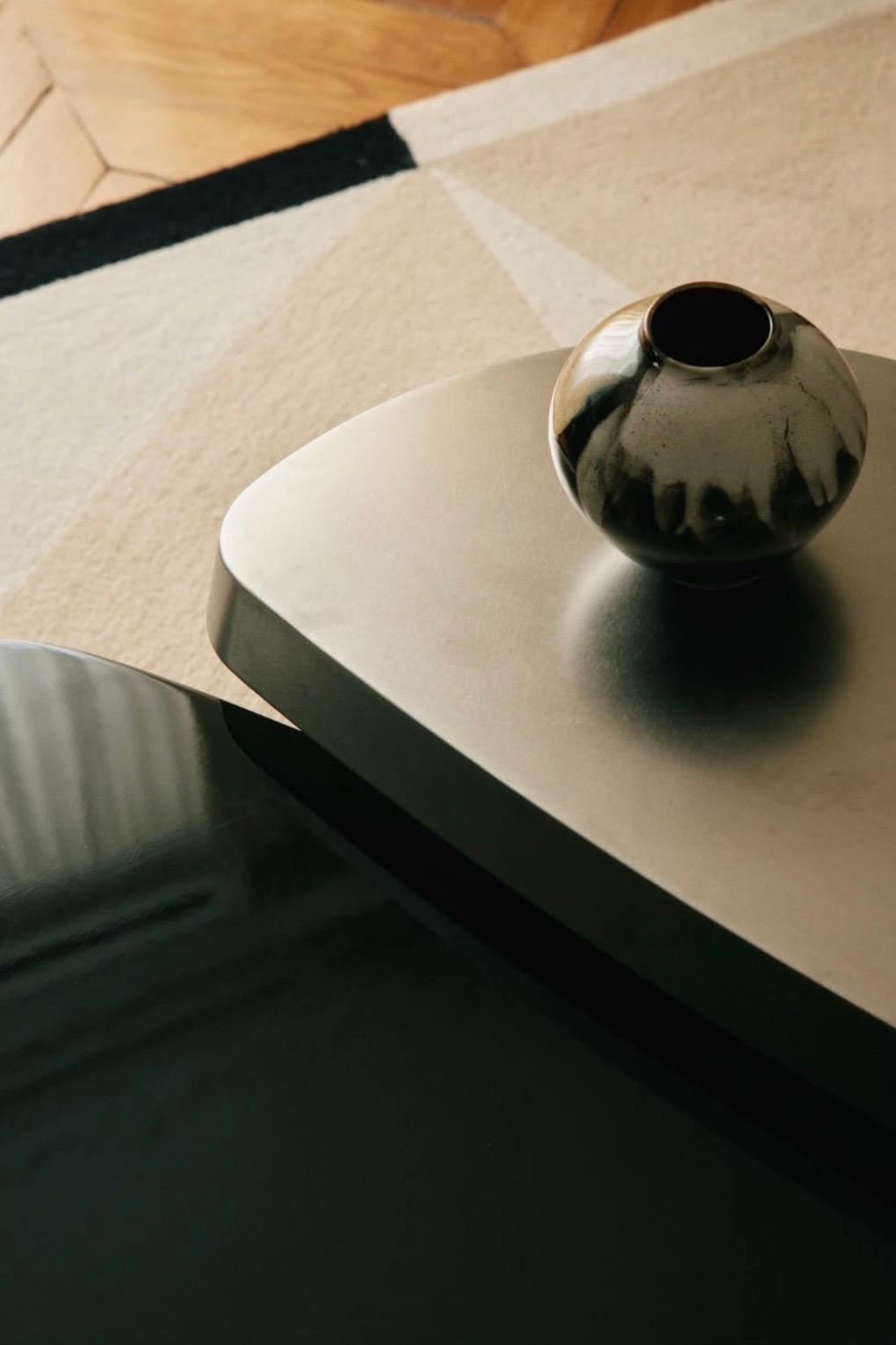 Détail d'un intérieur conçu par Studio VH : tables basses organiques, vase céramique et parquet en point de Hongrie